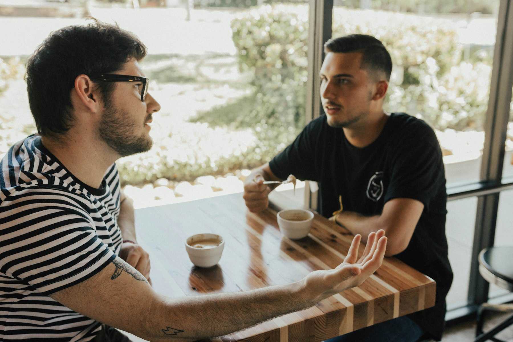 Two men talking over coffee at a table